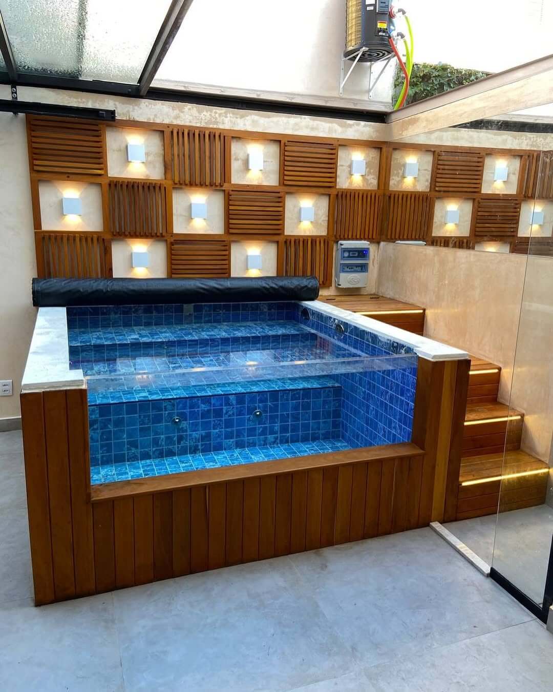 Spa com revestimento azul, parede de madeira e iluminação embutida